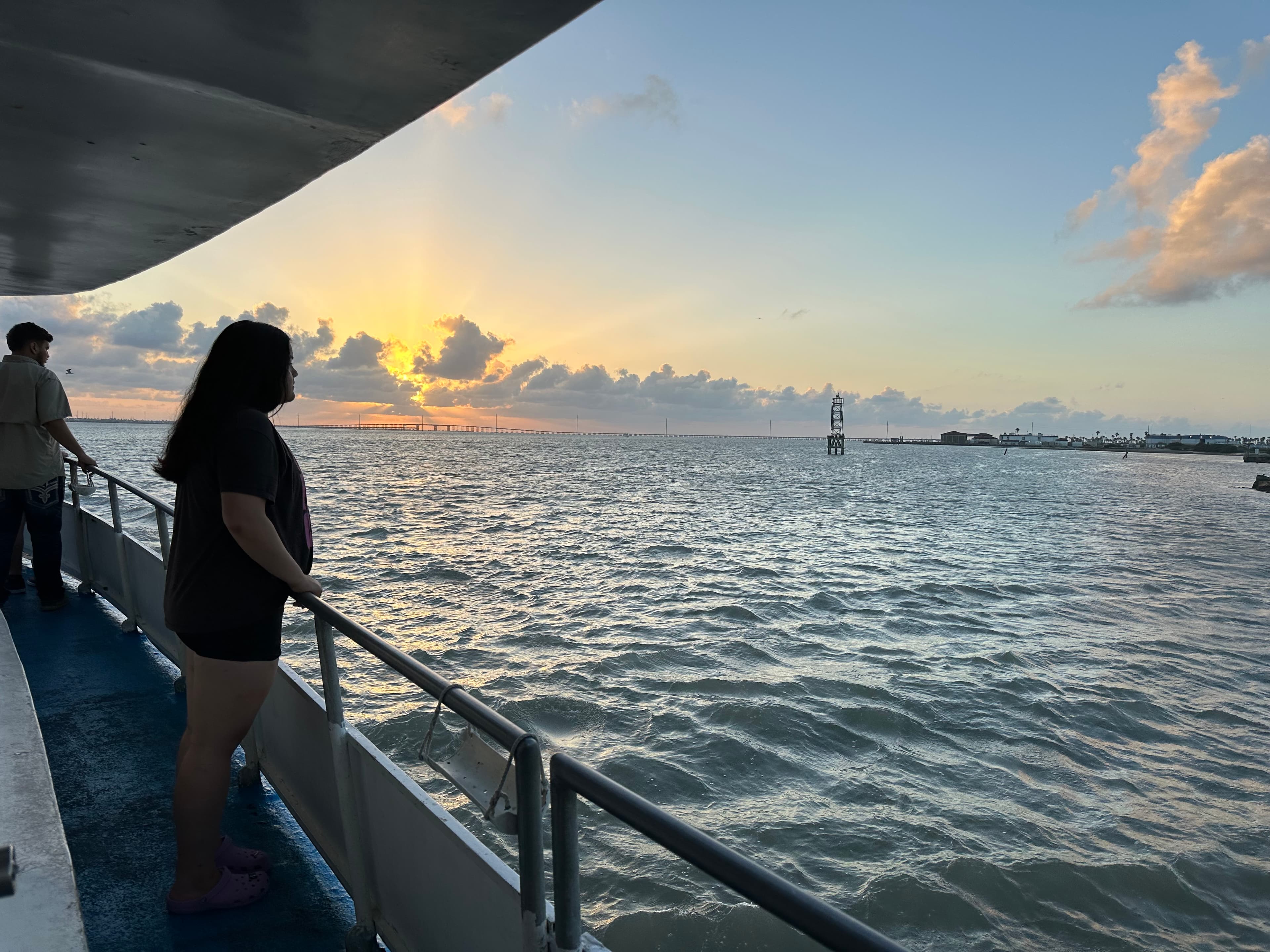 Girl on boat looking at sunset